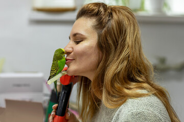 Tender feelings of a woman with her budgie