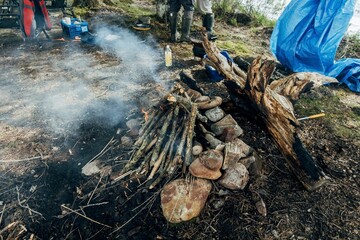 Burning firewood pile making fire for cooking that leaves smoke in a forest