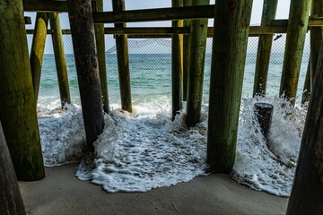 Magnificent view of foamy waves crashing into the pier at Seaside Heights New Jersey, on a sunny day