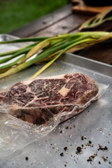 Vertical closeup shot of a slice of raw steak on a silver cooking board