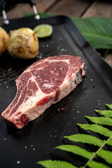 Beautiful shot of a raw steak meat next to the onions