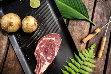 Beautiful shot of a raw steak meat next to the onions