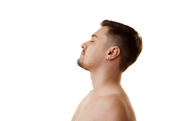 Naklejka premium Side view portrait of handsome man posing with closed eyes against white studio background. Selfcare. Concept of natural beauty, male health, anti-aging, spa procedures, cosmetic products.