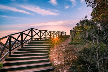 Scenic view of wooden stairs leading to the beach during sunrise