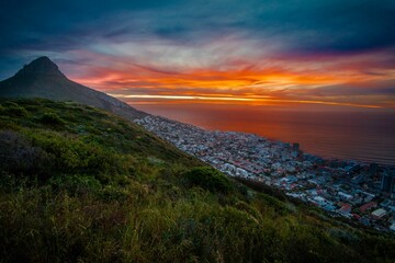 Gorgeous view of a mountainside town in Africa overlooking the calm sea at sunset