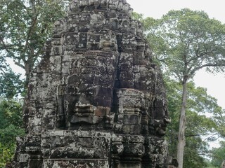 Image of a stone statue in front of trees in Angkor Wat, Cambodia