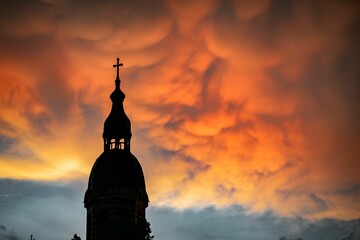 Closeup shot of a dome of a church against a red sunset sky background