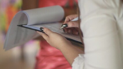 Closeup woman planner hands working completing wedding checklist
