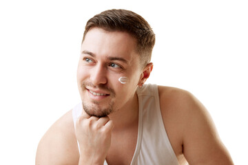 Obraz premium Young man brunette man with cream patches on face put his head on hand and looking away against white studio background. Concept of natural beauty, male health, anti-aging, spa procedures.
