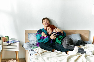 joyful appealing couple in vivid fashionable outfits hugging and laughing while in bed at home