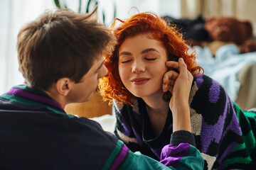 beautiful red haired woman with closed eyes enjoying her loving boyfriend company while at home