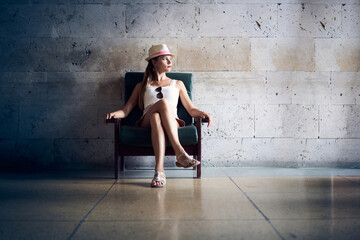 Portrait of young woman sitting alone inthe chair