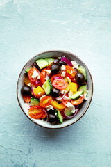 Greek salad. Fresh tomato, cucumber, bell pepper, Feta cheese, onion, and olives. Healthy summer food, overhead flat lay shot, vegetarian dish