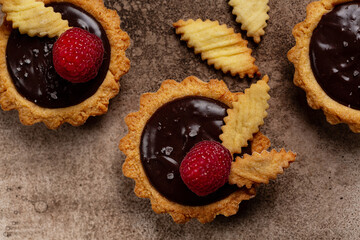 Top view of Salted Chocolate Mini Tarts with chocolate ganache cream and raspberry.