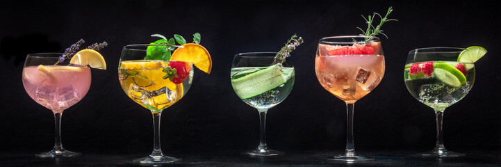 Fancy cocktails with fresh fruit panorama. Gin and tonic drinks with ice at a party, on a black background, a panoramic header