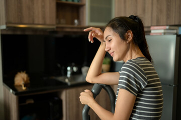 Young housewife wiping sweat from her forehead tired from housework