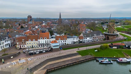 Fototapeten Beautiful view from above, from drone to orange, tiled roofs of houses. Top view of the Dutch city of Wijk bij Duurstede. The streets and roof of the church. Central Square of the city. © zlatoust198323