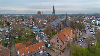 Fototapeten Beautiful view from above, from drone to orange, tiled roofs of houses. Top view of the Dutch city of Wijk bij Duurstede. The streets and roof of the church. Central Square of the city. © zlatoust198323