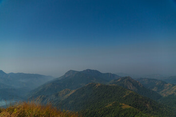 The sky is blue and the mountains are covered in trees