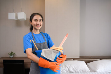 Professional cleaner woman in rubber gloves holding bucket with fabric clothes and brush to clean