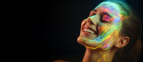 Portrait of a young happy woman with a rainbow glow on her face on a black background with space for text.