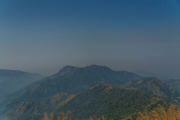 The sky is blue and the mountains are green
