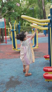 Cute little asian girl play on school kindergarten yard playground healthy summer activity for children. Child playing on outdoor playground
