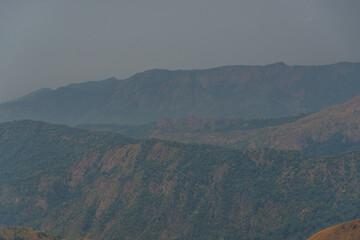 The mountains are covered in trees and the sky is cloudy