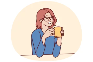 Selbstklebende Fototapeten Joyful woman holding coffee mug sitting at table and smiling remembering happy moments from life during lunch break. Girl in casual clothes drinks hot tea or coffee to gain vigor and energy © drawlab19
