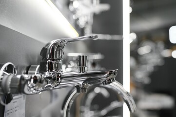 Water taps of different types and shapes on the counter in the store. Retail trade in sanitary ware. Foreground.