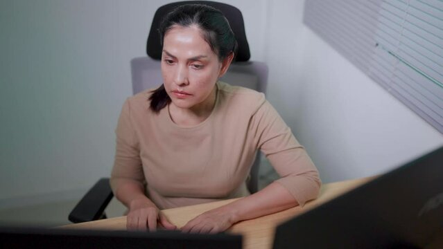 Asian woman working on desktop computer in startup office Experts are coding software for Big Data Blockchain projects.