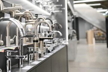Water taps of different types and shapes on the counter in the store. Retail trade in sanitary...