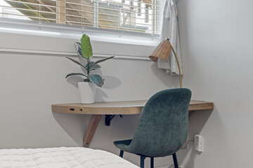 this bedroom has green chairs and a small desk near the bed