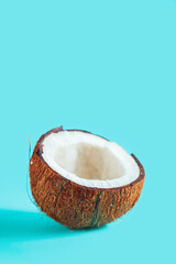 Broken coconut pieces on a blue background. - 779665097