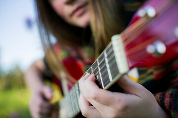 Close-up of a girl's hands playing the guitar. - 779665608