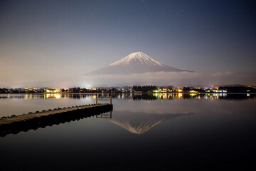 Mount Fuji and small pier in kawaguchiko lake at night.