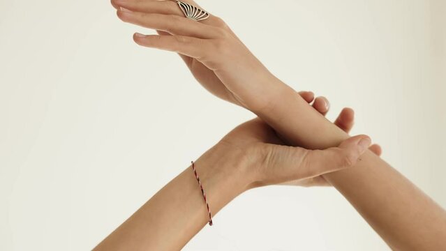 Closeup of elegant woman hands gently touching with a clear background, conveying a concept of grace and beauty.