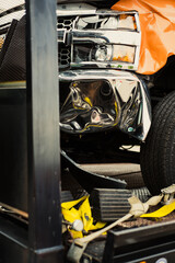 Toned photo smashed bumper front fender on pickup truck by car accident on flatbed rollback tilt...