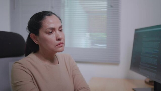 Close-up of a freelance woman sitting and writing code. she feels tired
