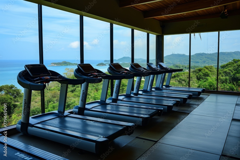 Poster a row of treadmills lined up in front of a large window, providing a view of the ocean, a row of tre