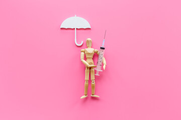 Medical insurance concept - wooden dummy man with umbrella - obrazy, fototapety, plakaty