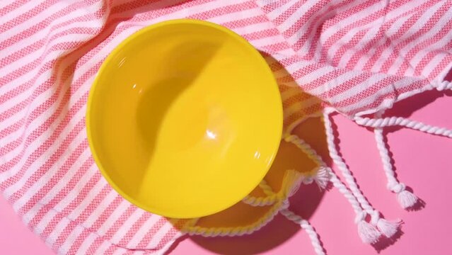 Caramelized popcorn dropping down into a yellow bowl