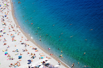 stone beach and turquiose water wave of cote dAzur at Nice at summer, Riviera, France, top view