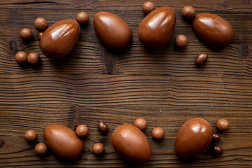 Chocolates background with chocolate eggs and sweets, top view