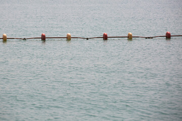 A line of yellow buoys stretches into the Aegean Sea
