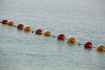 A line of yellow buoys stretches into the Aegean Sea