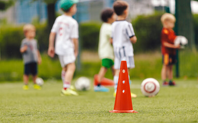 Soccer Class for Kids. Physical Outdoor Activities for Kids. Children Running at Practice Field. Elementary-Age Children at Slalom Training Drill