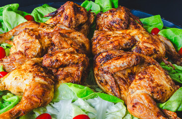 Grilled whole chicken on freshly picked lettuce leaves.