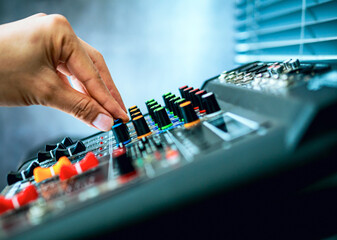 Close-up of sound engineer hands adjusting control sound mixer in recording, broadcasting...