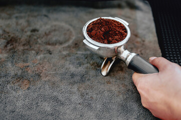 Equipment of coffee maker coffee portafilter filled with finely ground coffee In the hands of the...